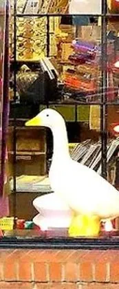 One of the white goose figures standing behind the shop window, with an orange beak and orange feet.